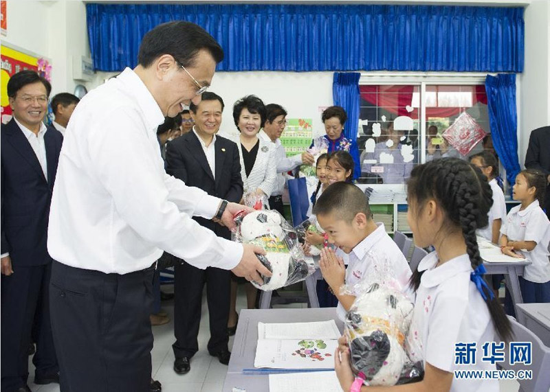 10月13日，正在泰國訪問的國務(wù)院總理李克強參觀具有110多年歷史的清邁崇華新生華立學(xué)校。這是李克強向三年級學(xué)生贈送大熊貓玩具。新華社記者 黃敬文 攝