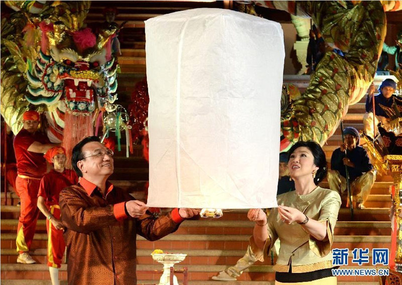 10月12日晚，中國國務(wù)院總理李克強在泰國清邁與泰國總理英拉身穿民族服裝，共同放飛“孔明燈”，為中泰友好祝福。 新華社記者 劉建生 攝 