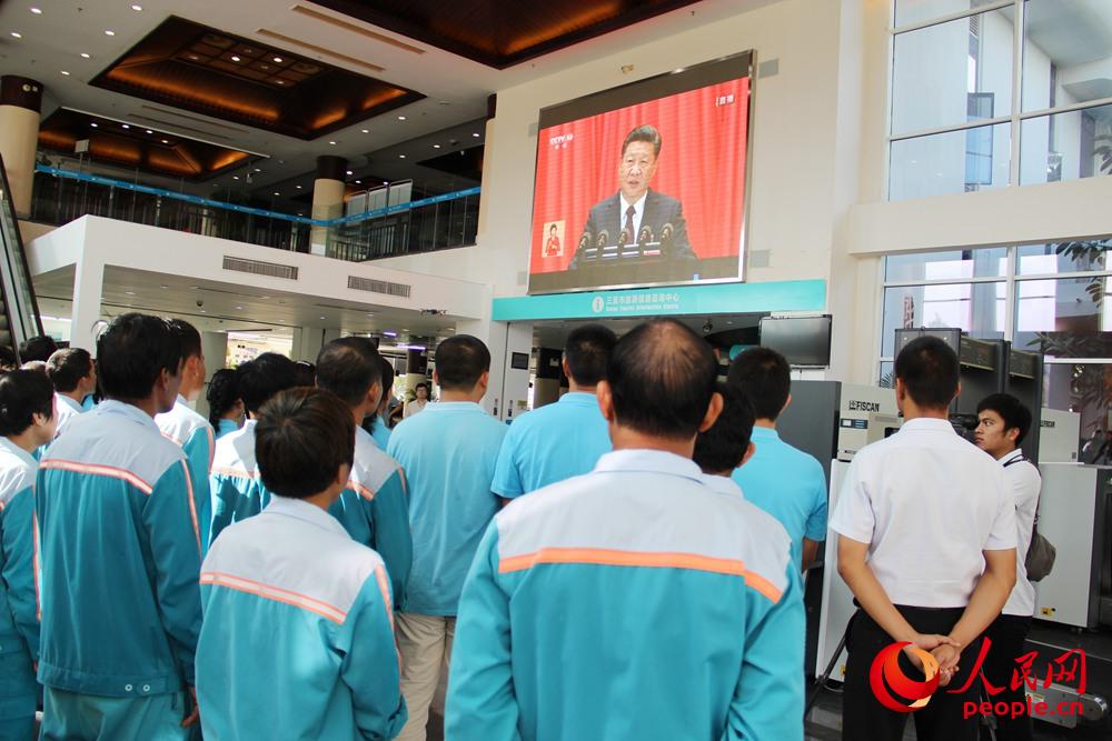 10月18日上午，海南三亞國際郵輪港干部職工和游客一起觀看黨的十九大開幕會。人民網(wǎng)吉羽 攝