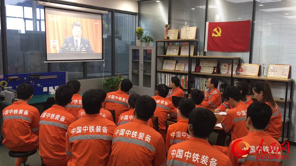 10月18日上午，在河南鄭州中鐵工程裝備集團(tuán)有限公司盾構(gòu)總裝車間“大國(guó)工匠”工作室內(nèi)，工友們正在觀看十九大開幕會(huì)。人民網(wǎng)慎志遠(yuǎn) 攝