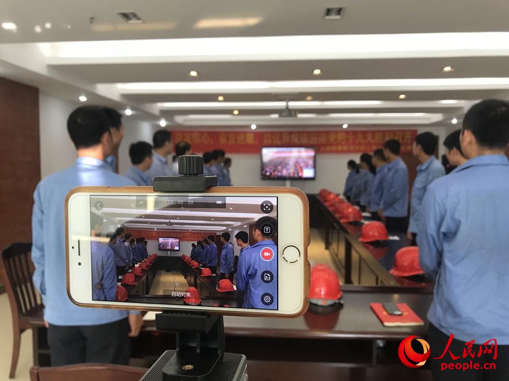 10月18日上午，廣西北海鐵山港作業(yè)區(qū)港口員工觀看黨的十九大開(kāi)幕會(huì)。人民網(wǎng)王芳 攝