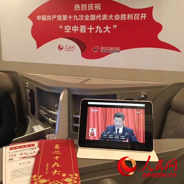 10月18日上午，在東方航空飛機(jī)上收看十九大開幕會(huì)。人民網(wǎng)宋麗雲(yún) 攝