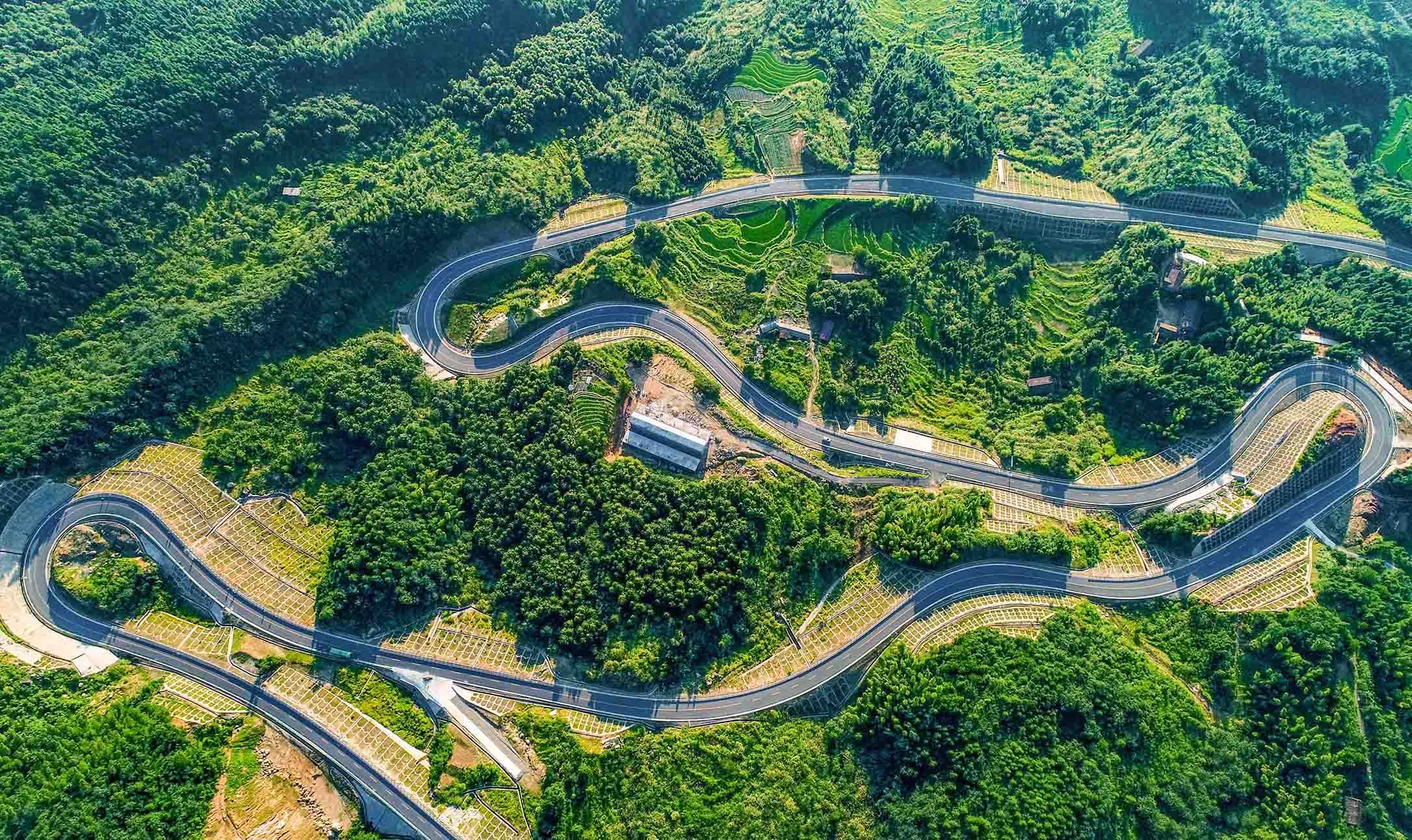 行走在江西省九江市武寧縣，一條條縱橫交錯的農(nóng)村道路將沿線的自然生態(tài)、秀美鄉(xiāng)村和人文風(fēng)情串聯(lián)起來，織就了一幅“車在綠中行、人在畫中游”的美麗畫卷。圖為武寧縣羅溪鄉(xiāng)坪源村修在深山裡的“致富”路。
