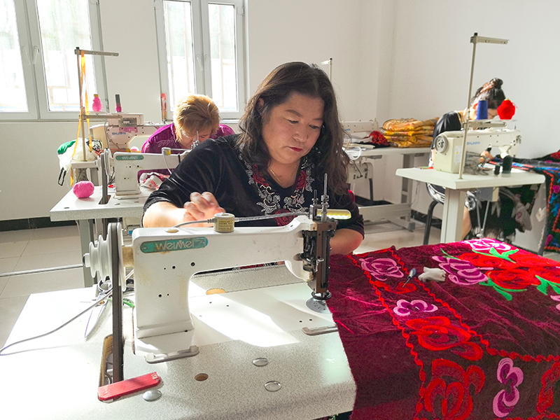 吐孔·沙熱帶領(lǐng)社員一起趕制訂單。人民網(wǎng)記者 楊睿攝