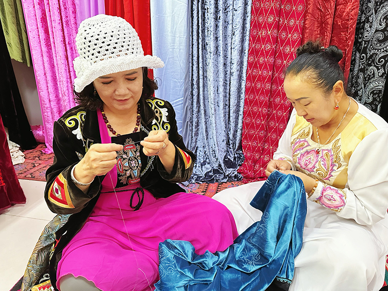 在兵團(tuán)第三師托云牧場(chǎng)，退休教師加米亞提·司馬義（左一）利用業(yè)余時(shí)間來到合作社工作。人民網(wǎng)記者 楊睿攝