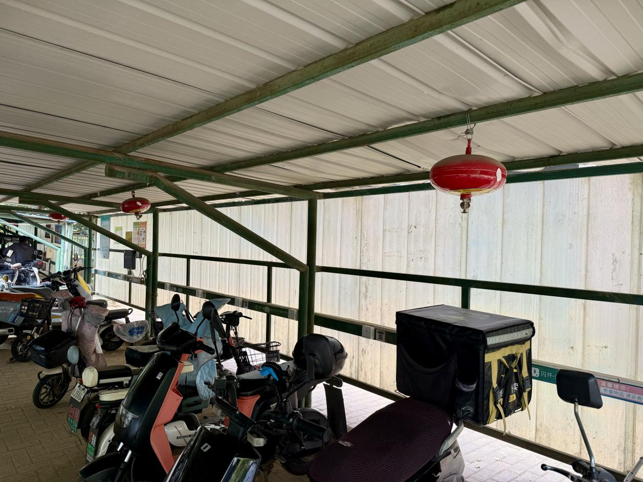 青和居小區(qū)電動(dòng)車棚配備了懸掛式溫感滅火器。人民網(wǎng)記者 周恬攝