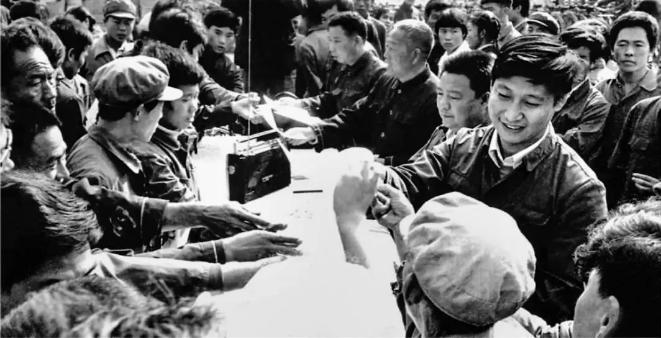1984年10月，習(xí)近平在正定縣城街頭發(fā)放民意調(diào)查表。（圖源：《讓群眾過(guò)上好日子——習(xí)近平正定足跡》）