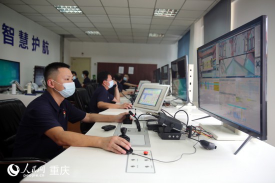 胡萬琪在遠(yuǎn)程操控室收發(fā)集裝箱。人民網(wǎng) 劉政寧攝
