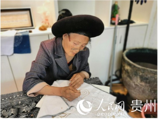趙開英老人正在聚精會(huì)神地繪制產(chǎn)品圖案。人民網(wǎng) 王欽攝