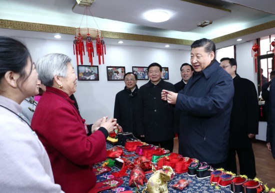 2017年12月12日，習(xí)近平來(lái)到江蘇徐州馬莊村考察，看到村民們手工制作的特色香包，連連稱贊“真不錯(cuò)”“很精致”。這是習(xí)近平在香包制作室與村民王秀英老人交流。 新華社記者 鞠鵬 攝