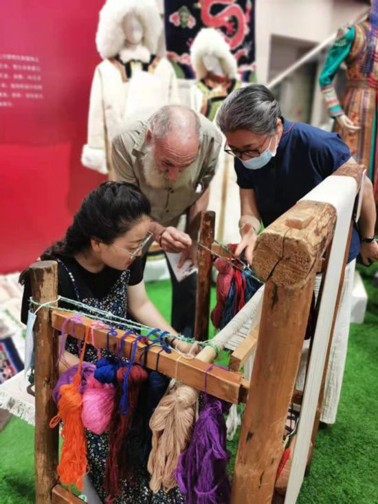 楊永良的學(xué)生在展會上向客商介紹加牙藏毯編織技藝。受訪者供圖